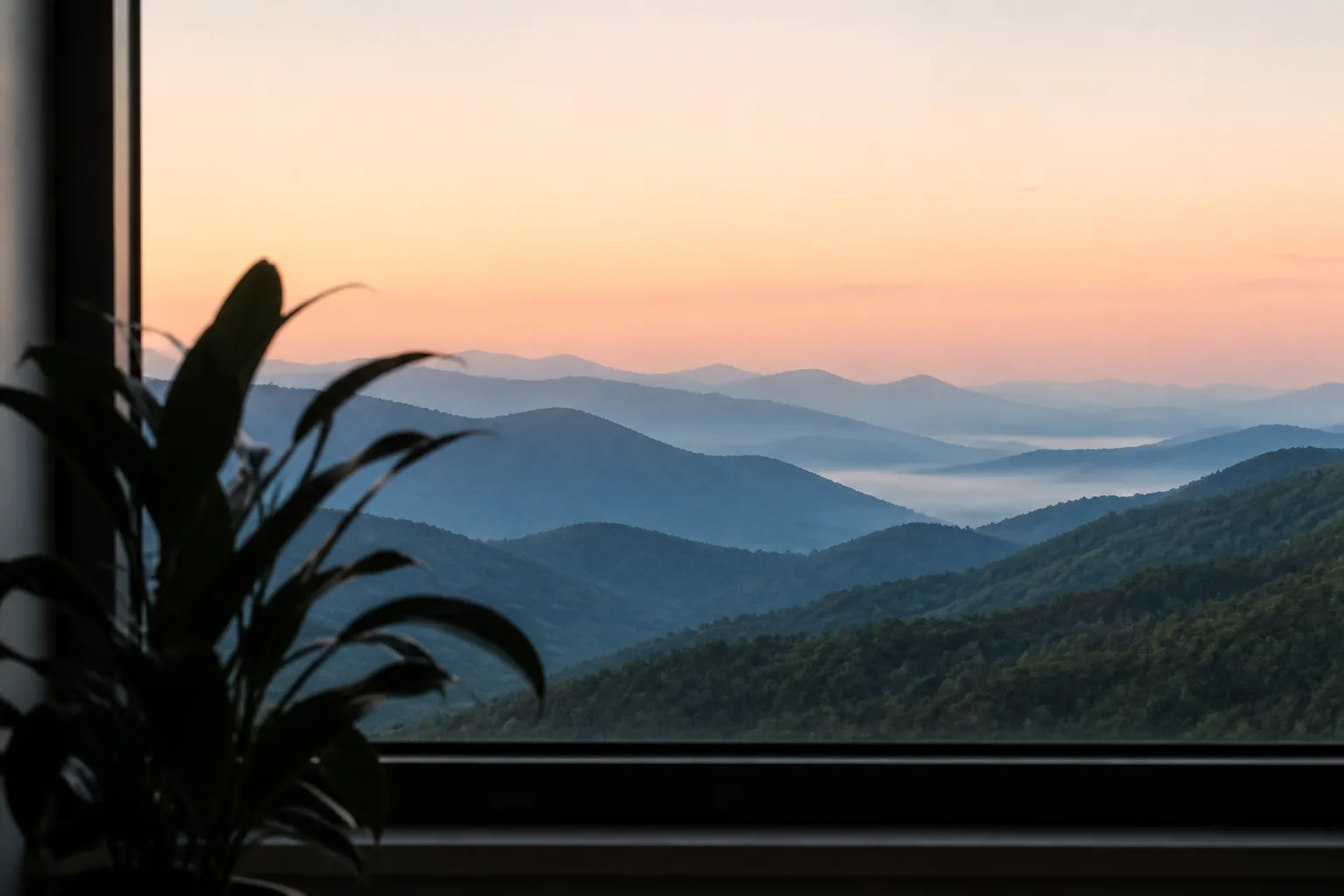 Warm sunrise across a layered mountain landscape